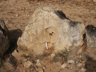 Kultstein mit Durchbohrung und Kerze in der neolithischen Kultanlage von Sedouikech auf Djerba